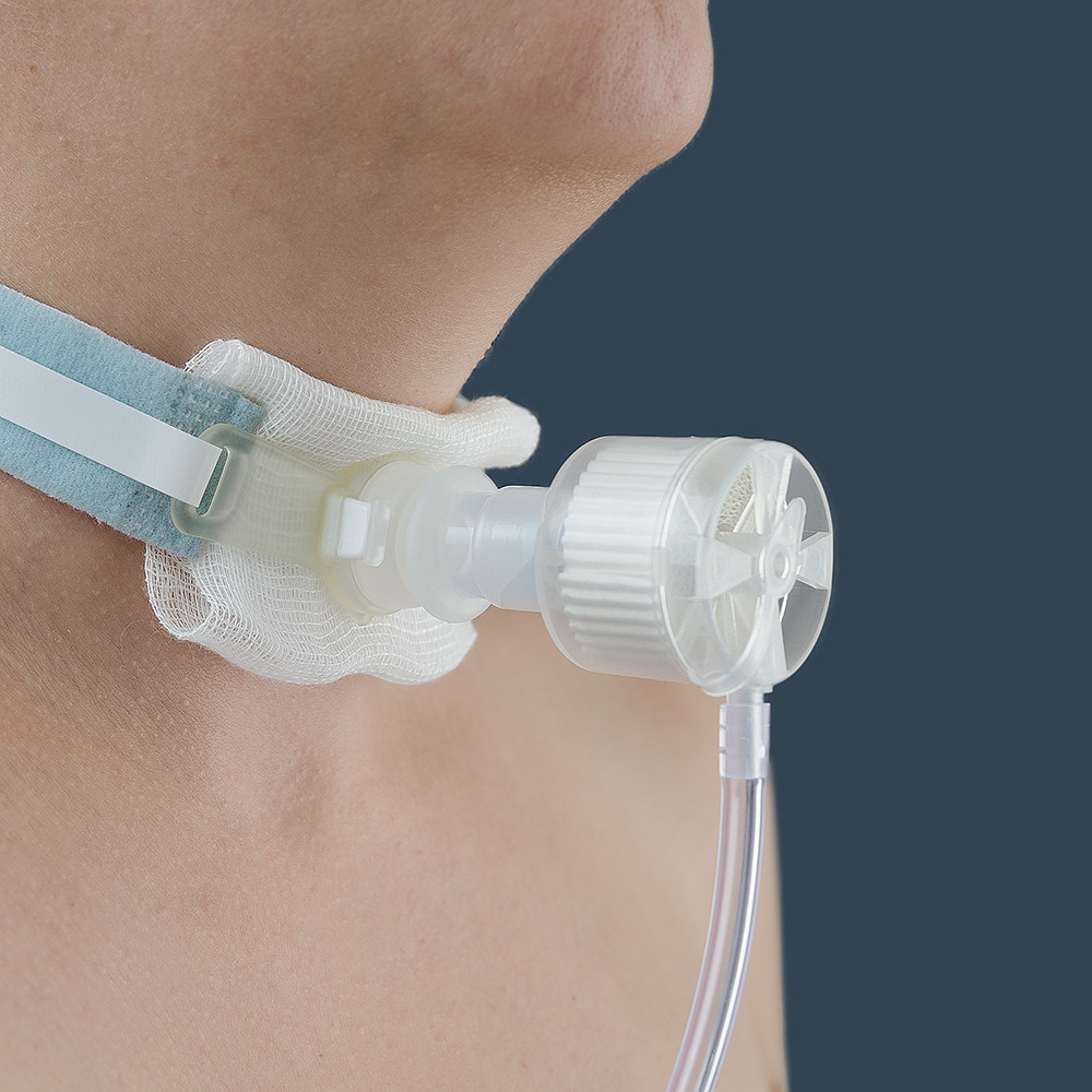 Фильтр дыхательный с тепловлагообменником из бумаги и кислородной трубкой, для трахеостомы на пациенте
